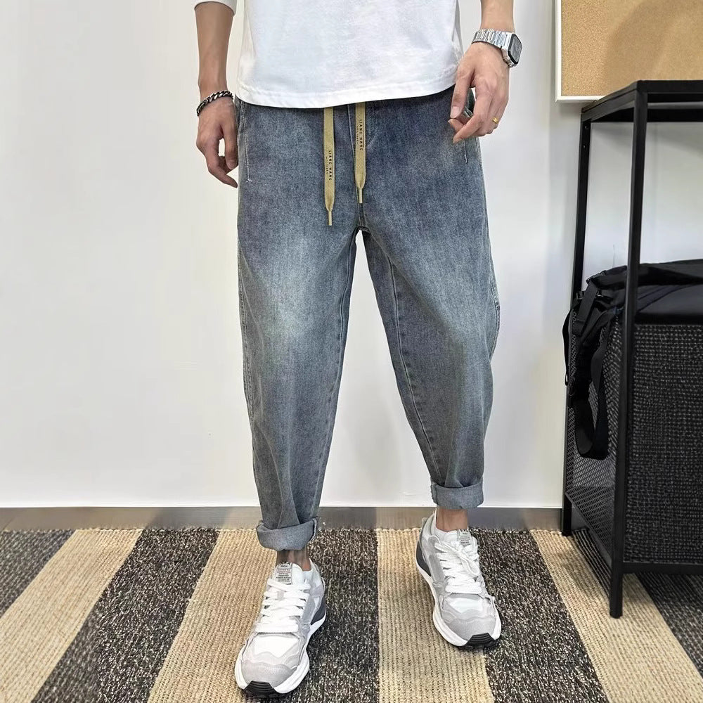 Men’s blue loose-fit harem jeans with an elasticated mid-rise waist, straight legs, zipper fly and moderate stretch.