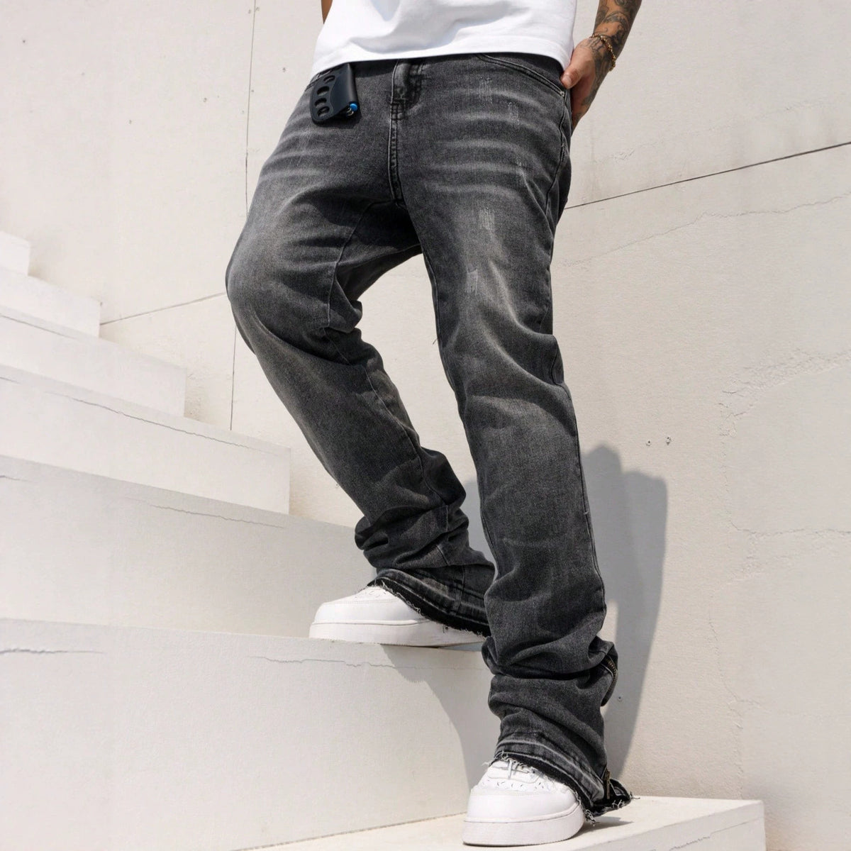 Men’s relaxed-fit stretch jeans with a mid-rise waist, straight-leg cut and slightly flared hem, available in black and blue.