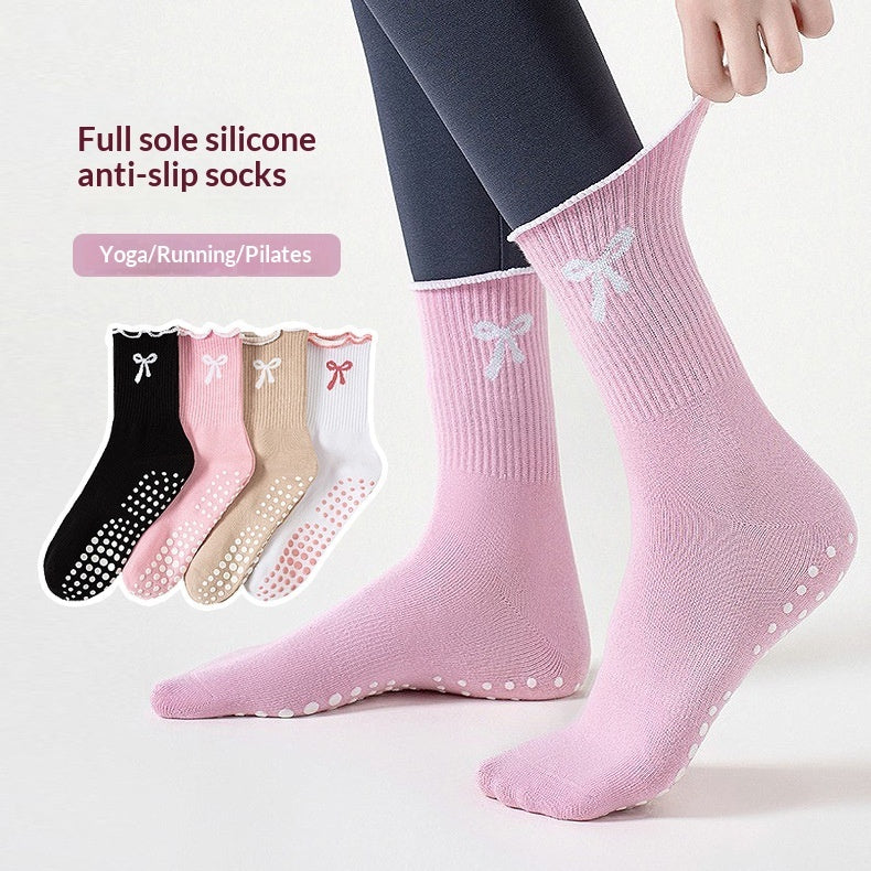 Women’s cotton mid-calf yoga socks with decorative ruffled cuffs, bow-inspired details and non-slip grip soles in black, khaki, pink and white.
