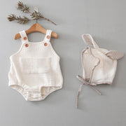 Cotton newborn triangle-style jumpsuit with a matching hat, available in pink and a light neutral colour.