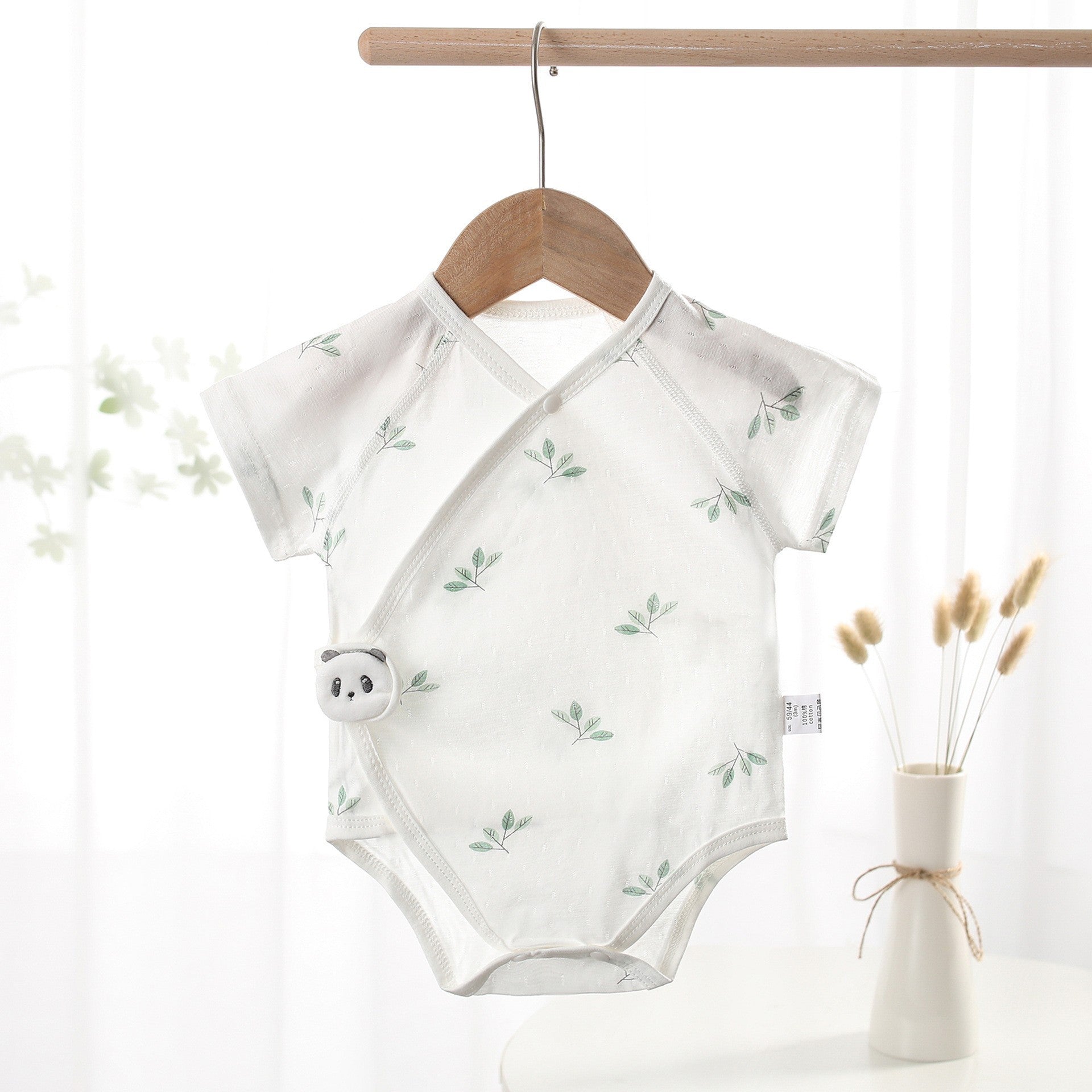 Short-sleeve cotton baby tie romper with a diagonal front opening, available in puppy, panda and pineapple prints.