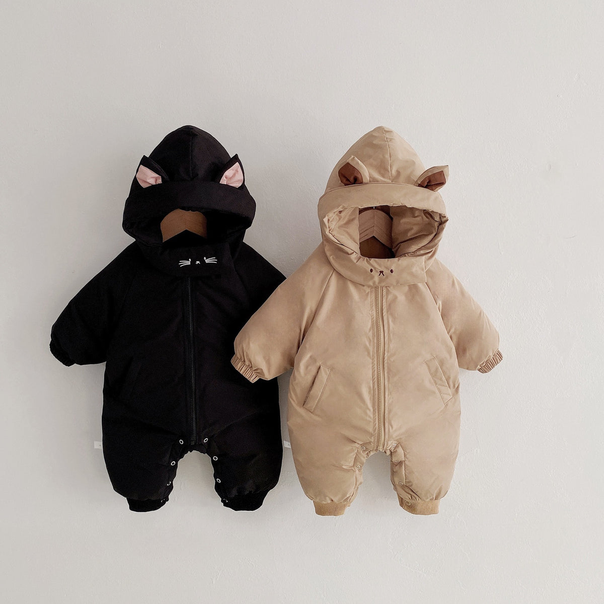 Thick hooded baby winter jumpsuit with long sleeves and a front zip, available in black and khaki.