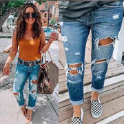 Women’s blue mid-rise skinny jeans with washed denim, distressed ripped details and a tapered pencil-leg fit