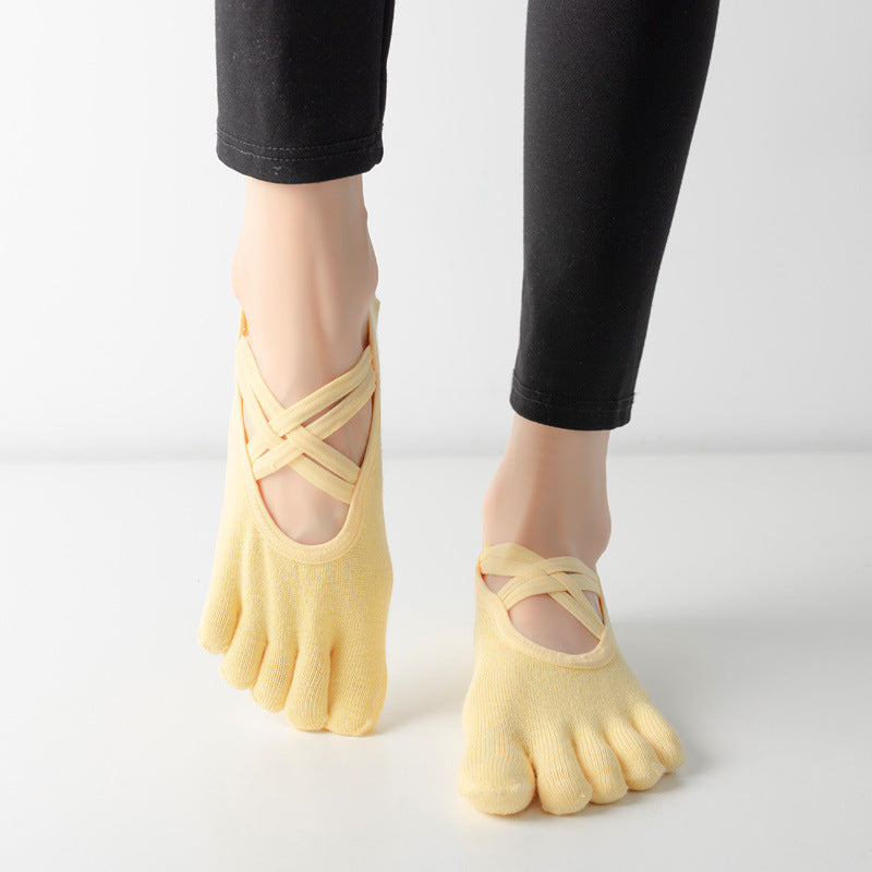 Women wearing yellow five-toe ballet yoga socks with elastic cross straps and a low-cut combed cotton design
